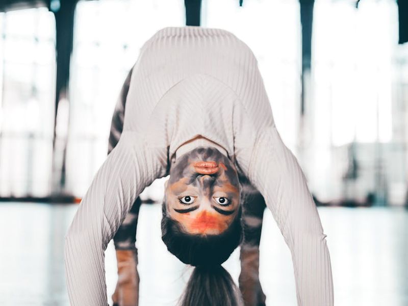 Person performing a smooth yoga transition in a studio.