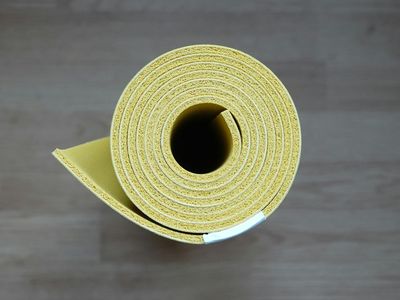 Rolled yoga mat leaning against the wall.